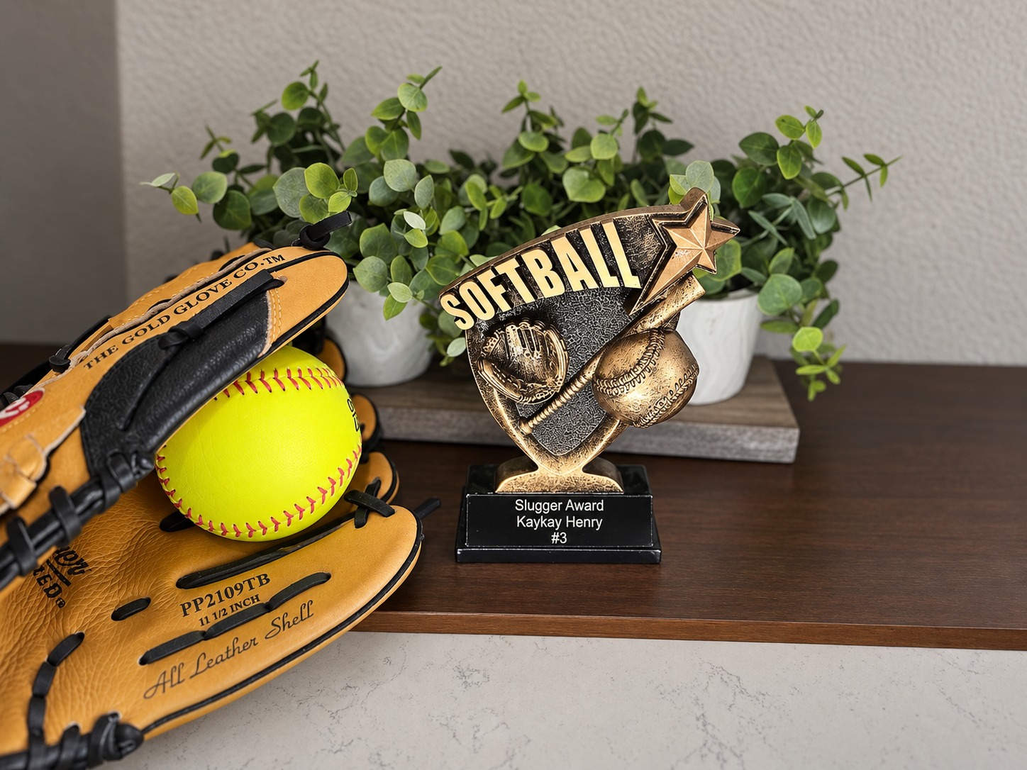 Personalized Slugger Award softball trophy displayed beside a glove and softball