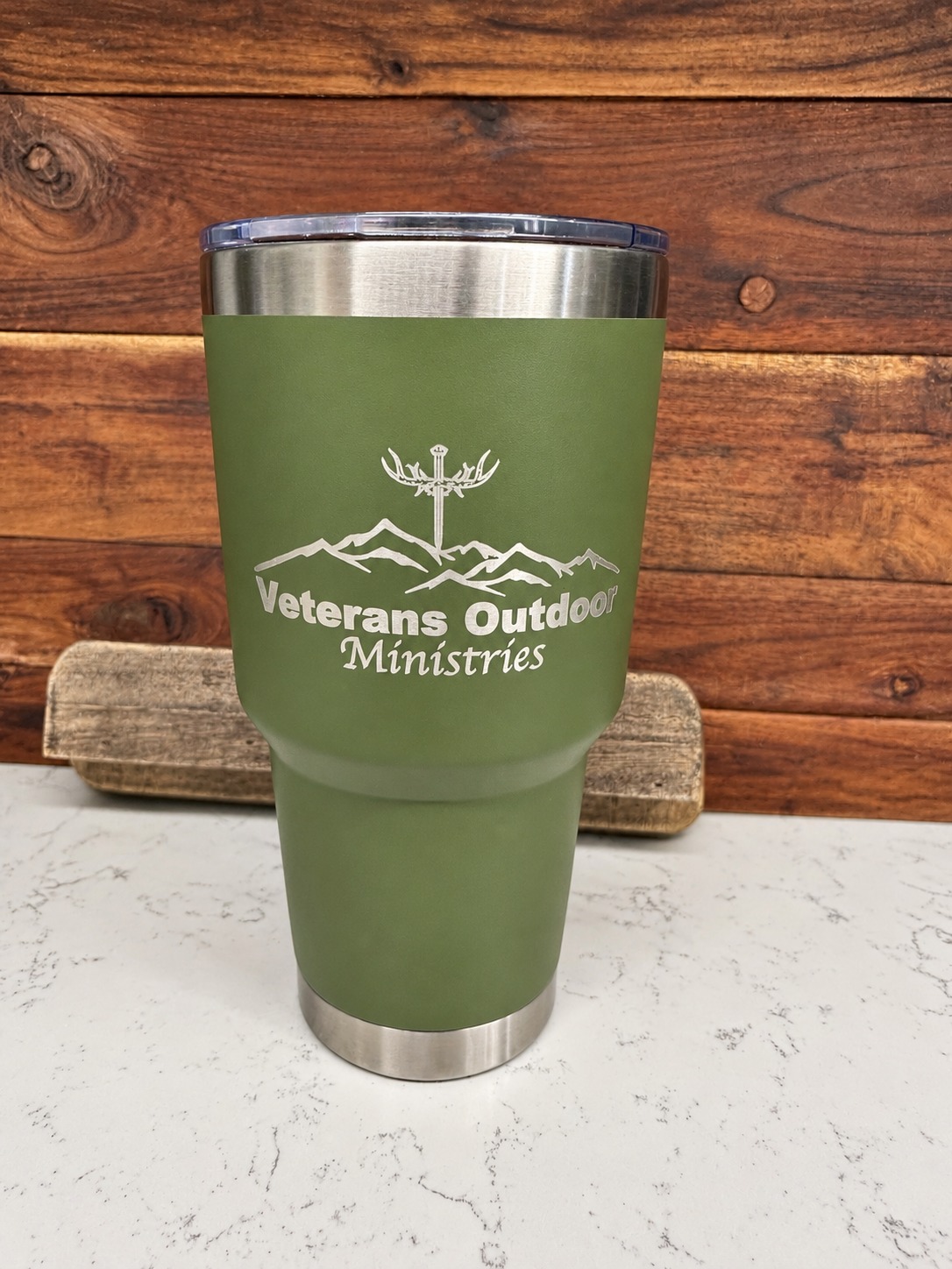 Green tumbler engraved with the Veterans Outdoor Ministries logo