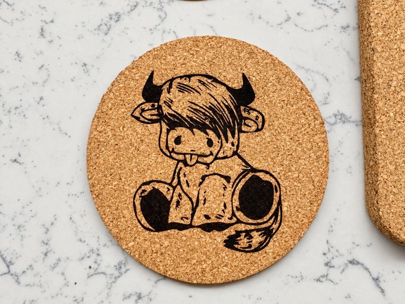 Round cork coaster engraved with a Highland cow illustration