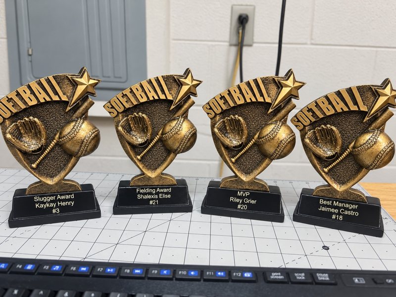 Four personalized softball trophies with engraved player and award plates